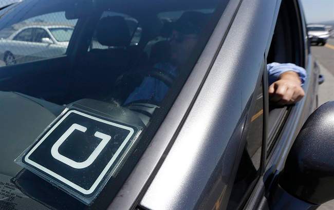In this July 15, 2015 file photo, Uber driver Karim Amrani sits in his car parked near the San Francisco International Airport parking area in San Francisco.