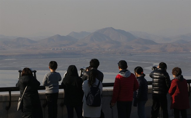 Visitors use binoculars to see the North Korean territory from the unification observatory in Paju, South Korea, Wednesday, Feb. 10, 2016. South Korea said Wednesday that it would suspend operations at a joint industrial park with North Korea in response to the North's recent rocket launch, the first time in the park's decade of operation that Seoul has halted work there. (AP Photo/Lee Jin-man).