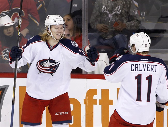 Columbus Blue Jackets' William Karlsson, left, from Sweden, celebrates with teammate Matt Calvert after scoring the game winning goal against the Calgary Flames during third period NHL action in Calgary, Alta., Friday, Feb. 5, 2016. 