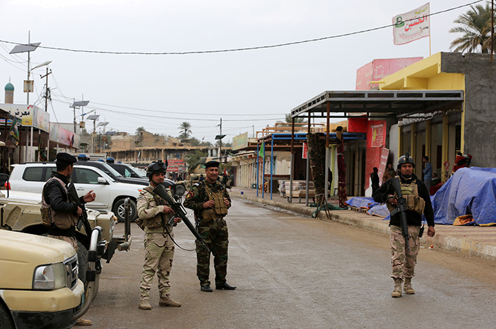 Iraqi policemen guard the area as Sunni and Shiite tribal clerics and leaders meet to discuss reconciliation between the Muslim sects and recent sectarian violence in the town of Muqdadiyah, northeast of Baghdad on January 23, 2016.  