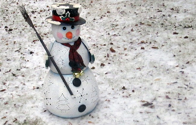 A leftover Christmas artificial snowman is displayed Monday, Feb. 16, 2016, off HWY 70 after snow and ice spread over Durham and Orange Counties in North Carolina. 