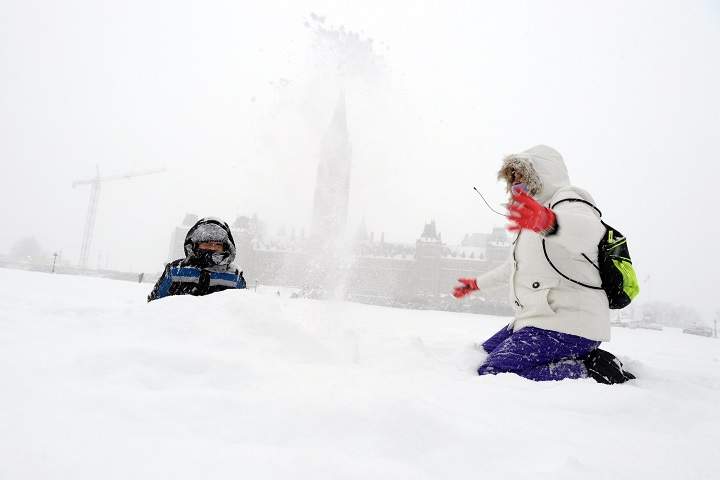 Brandon, 5, from Miami experieces snow for the first time as he plays with his mom on Parliament Hill as a major winter storm hits Ottawa on Tuesday, Feb. 16, 2016. 