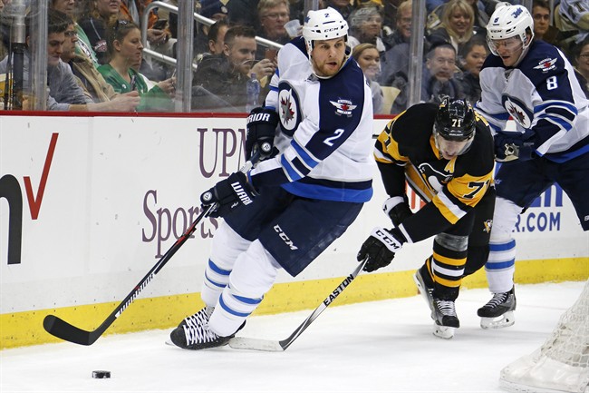 Pittsburgh Penguins' Evgeni Malkin hits the skate of Winnipeg Jets' Adam Pardy to draw a tripping penalty during the second period of an NHL hockey game in Pittsburgh on Saturday, Feb. 27, 2016. 