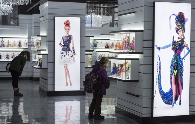 Visitors admire Barbie dolls at Barbie Expo, a permanent exhibit that celebrates the best-selling doll's nearly six decades as a fashionista, Friday, February 12, 2016 in Montreal.