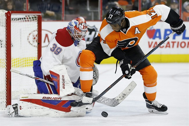 Philadelphia Flyers' Wayne Simmonds, right, tries to get control of the puck in front of Montreal Canadiens' Mike Condon.