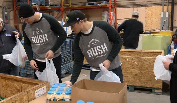 Rush players Mark Matthews and Adrian Sorchetti spent time Tuesday packing hampers for people in need.