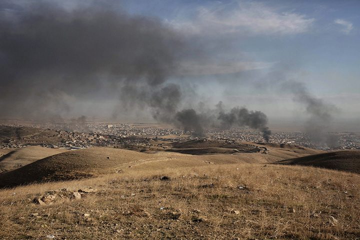 In this Nov. 12, 2015 file photo, smoke rises over Sinjar, northern Iraq from oil fires set by Islamic State militants as Kurdish Iraqi fighters, backed by U.S.-led airstrikes, launch a major assault. 