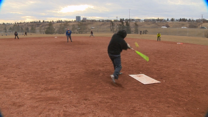 File photo of some people playing softball in Calgary on Feb. 28, 2016.