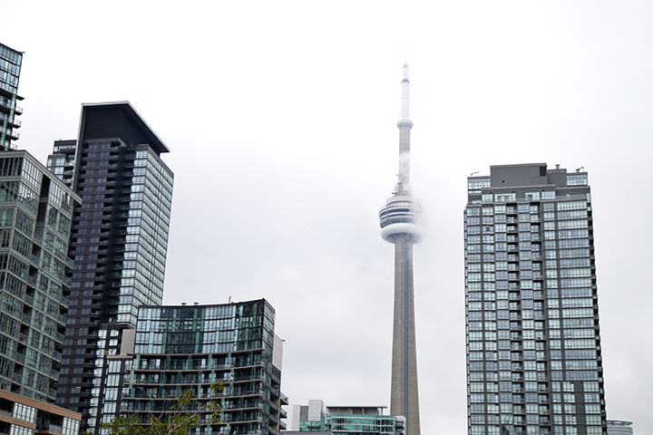 The CN Tower is barely visible amidst the looming grey clouds in these photos taken on June 30, 2015 in Toronto's downtown core.