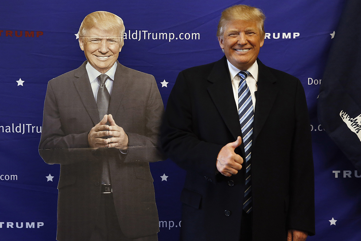 Republican presidential candidate Donald Trump poses with a cutout while visiting his campaign office, Tuesday, Feb. 16, 2016, in Greenville, S.C.