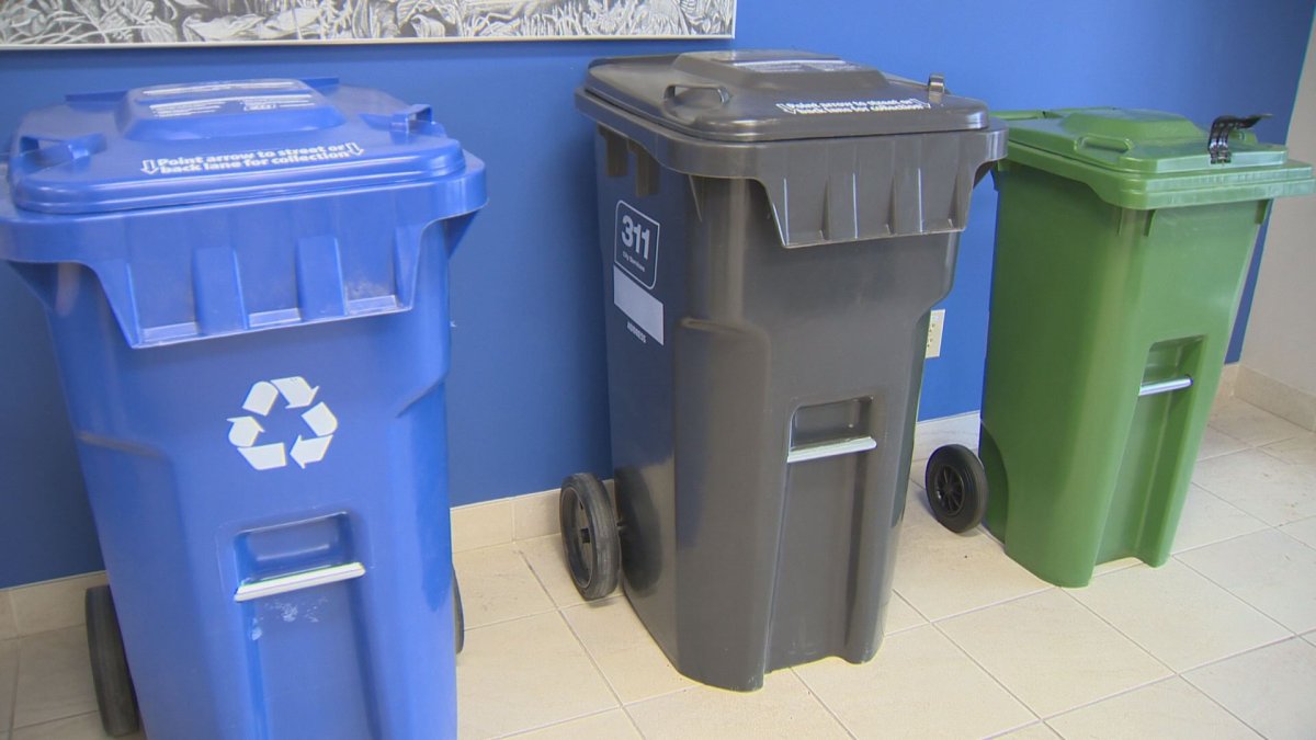 Organic bin shown with garbage and recycling during news conference.