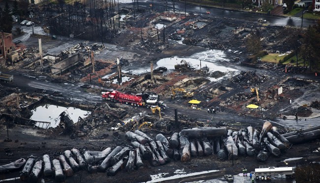 FILE - In this July 9, 2013 file photo, workers comb through debris after a train derailed causing explosions of railway cars carrying crude oil in Lac-Mégantic, Quebec.
