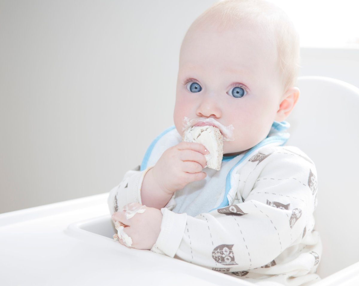 FILE: A baby with messy face eating.   