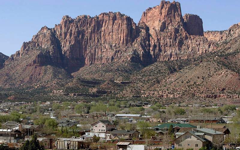 Hildale, Utah sitting at the base of red rock cliff mountains with its sister city, Colorado City, Ariz. in the foreground. 