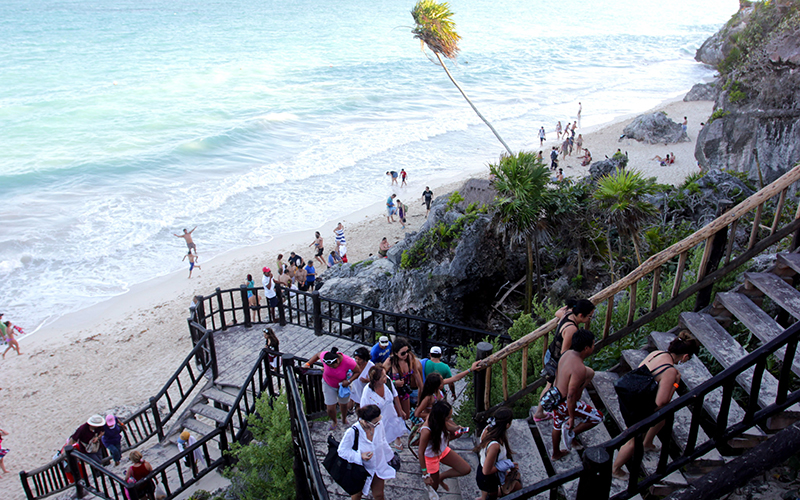 A line of people leave the swimming beach in Tulum, Mexico. 