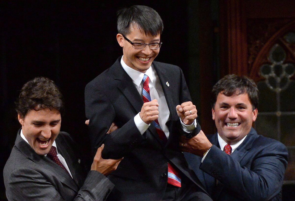 Liberal Leader Justin Trudeau and MP Dominic LeBlanc, right, escort new Liberal MP Arnold Chan in the House of Commons on Parliament Hill in Ottawa on Sept. 15, 2014. 