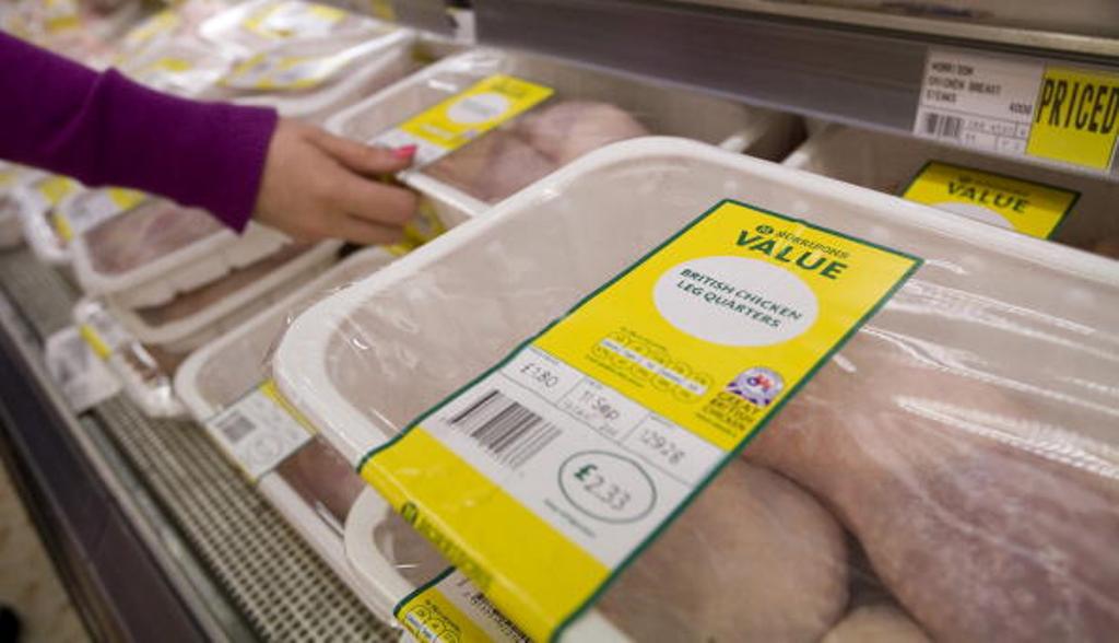 A customer selects a packet of chicken from the display at a Morrisons supermarket in Grays, U.K., on Sept. 7, 2010.