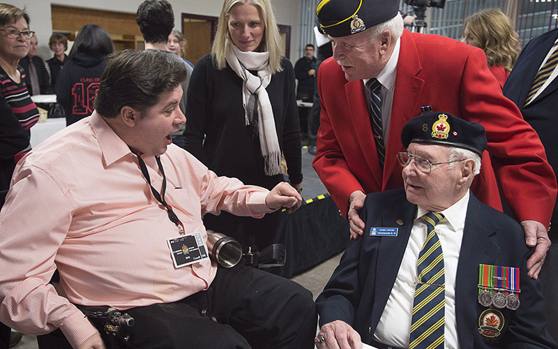 Veteran Affairs Minister Kent Hehr chats with veterans as Enviroment Minister Catherine McKenna, centre, looks on, as they attend a dinner at a local community centre in St. Andrews, N.B., on Monday, Jan. 18, 2016. 