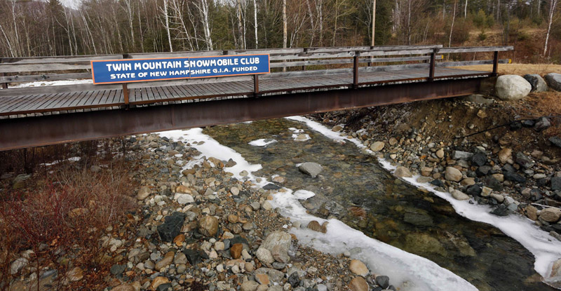 A bridge maintained by the Twin Mountain Snowmobile club is seen Wednesday Feb. 24, 2016, without any snow in Twin Mountain, N.H. It is part of thousands of miles of closed snowmobile trails in northern New England. 