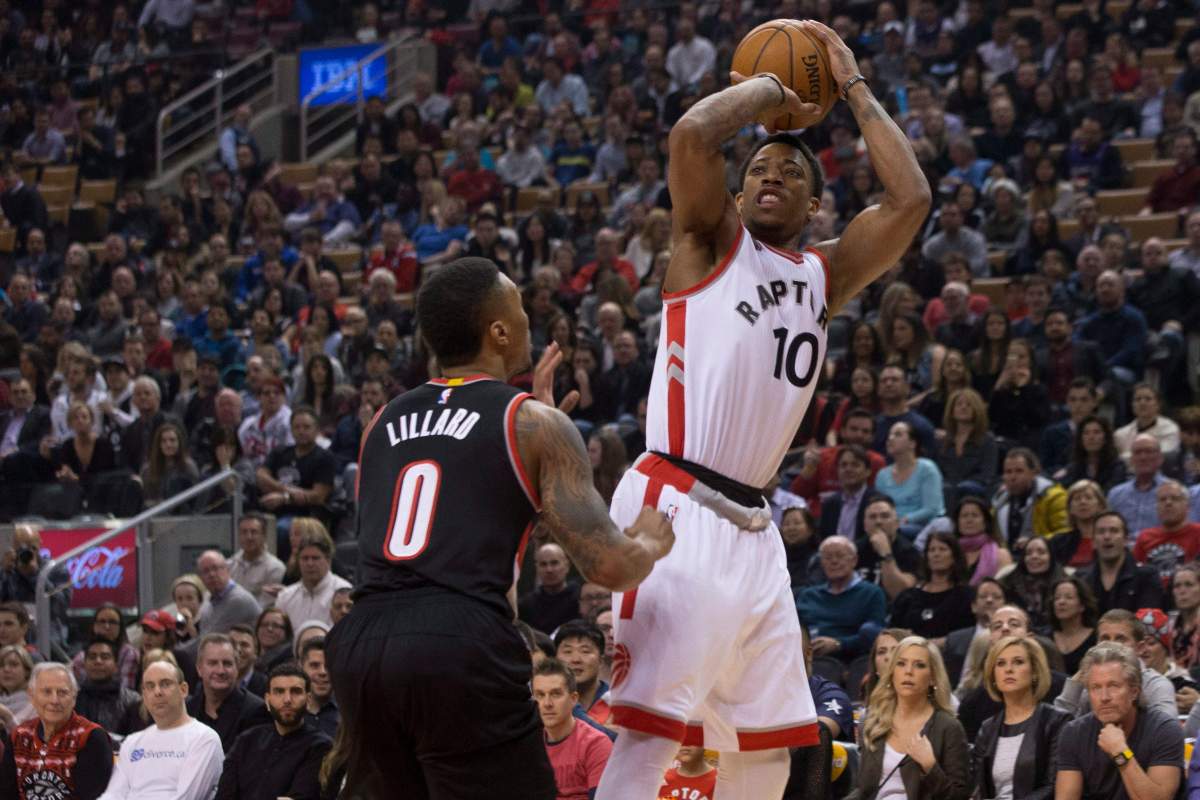 Toronto Raptors' DeMar DeRozan shoots on Portland Trail Blazers' Damian Lillard during first half NBA basketball action in Toronto on Friday March 4, 2016. 