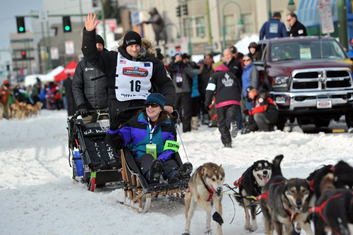 Defending Iditarod Trail Sled Dog Race champion Dallas Seavey (16) waves to the crowd as she begins the ceremonial start of the 1,000-mile race in Anchorage, Alaska, Saturday, March 5, 2016. 