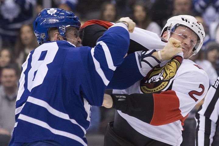 Toronto Maple Leafs’ Colin Greening, left, fights with Ottawa Senators’ Dion Phaneuf during first period NHL hockey action in Toronto on Saturday March 5, 2016.