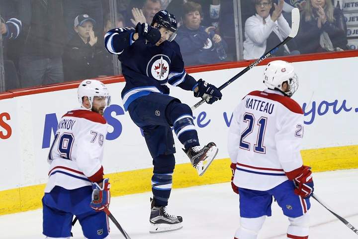Winnipeg Jets' Mark Scheifele (55) celebrates his second goal as Montreal Canadiens' Andrei Markov (79) and Stefan Matteau (21) skates by during third period NHL action in Winnipeg on Saturday, March 5, 2016. 