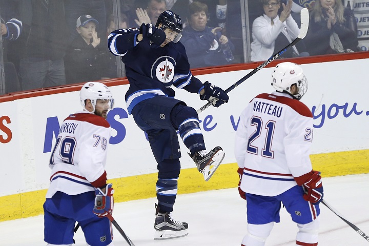 Winnipeg Jets' Mark Scheifele (55) celebrates his second goal as Montreal Canadiens' Andrei Markov (79) and Stefan Matteau (21) skates by during third period NHL action in Winnipeg on Saturday, March 5, 2016. 