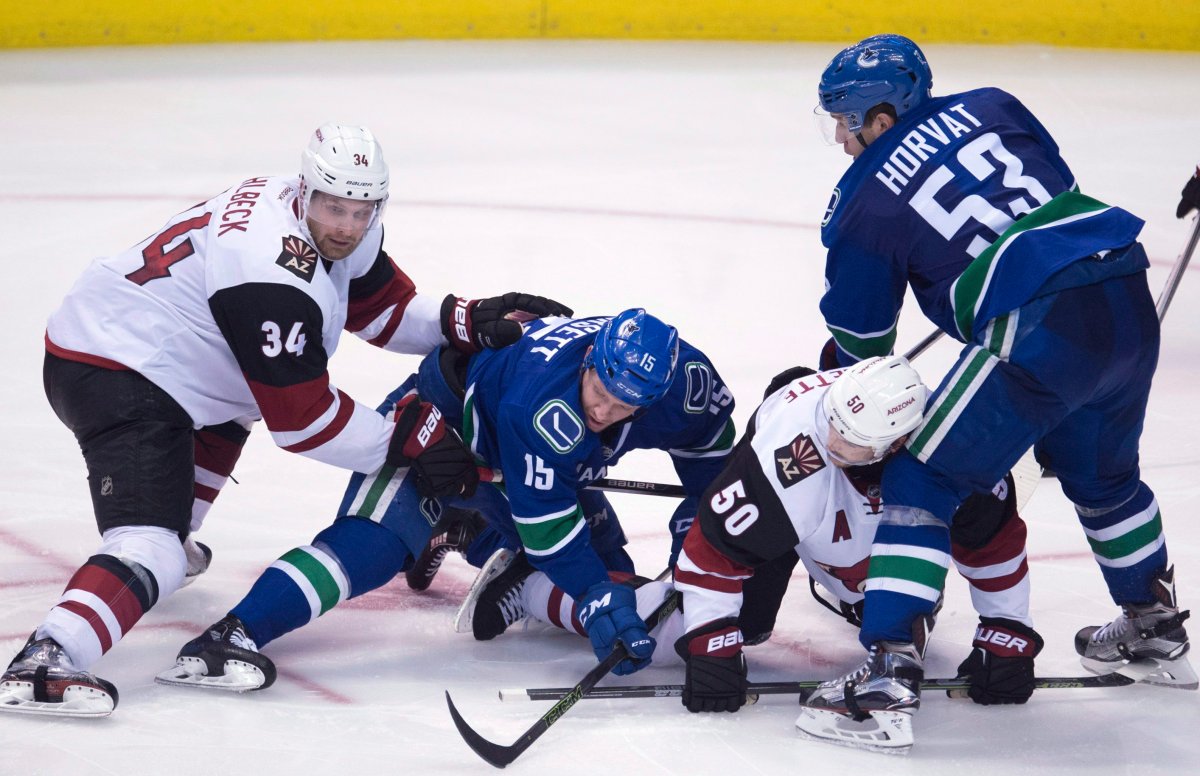 Vancouver Canucks center Bo Horvat (53) and Derek Dorsett (15) fight for control of the puck with Arizona Coyotes defenseman Klas Dahlbeck (34) and Antoine Vermette (50) during third period NHL action in Vancouver, B.C. Wednesday, March 9, 2016. 