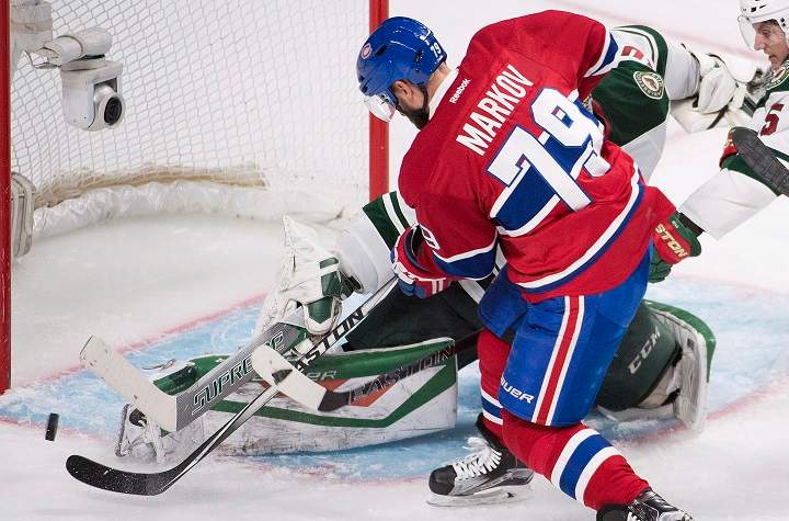 Montreal Canadiens' Andrei Markov moves in on Minnesota Wild's goalie Devan Dubnyk during third period NHL hockey action in Montreal on Saturday, March 12, 2016.