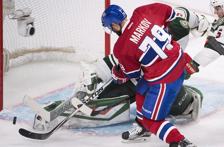 Montreal Canadiens' Andrei Markov moves in on Minnesota Wild's goalie Devan Dubnyk during third period NHL hockey action in Montreal on Saturday, March 12, 2016.
