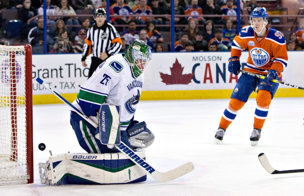 Vancouver Canucks' goalie Jacob Markstrom  is scored on as Edmonton Oilers' Connor McDavid skates in during second period NHL action. 