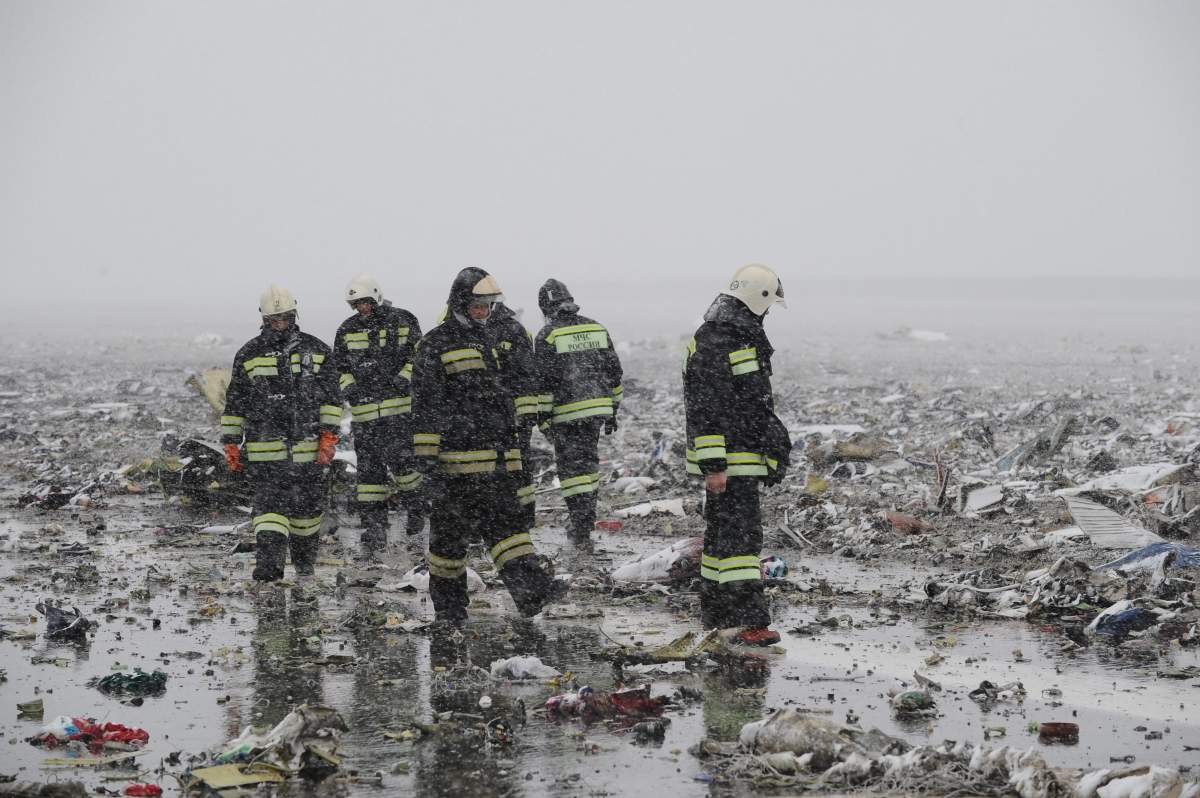 Russian Emergency Ministry employees are seen in the snow among the wreckage of a crashed plane at the Rostov-on-Don airport, about 950 kilometers (600 miles) south of Moscow, Russia Saturday, March 19, 2016. A Dubai airliner crashed and caught fire early Saturday while landing in strong winds in the southern Russian city of Rostov-on-Don, officials said. ()