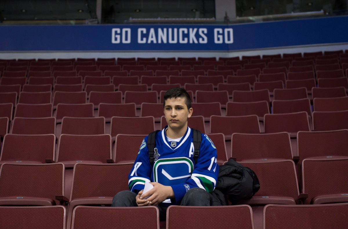 Syrian refugee Shergo Kurdi, 15, watches St. Louis Blues NHL hockey practice after a tour of Rogers Arena in Vancouver, B.C., on Saturday March 19, 2016. 