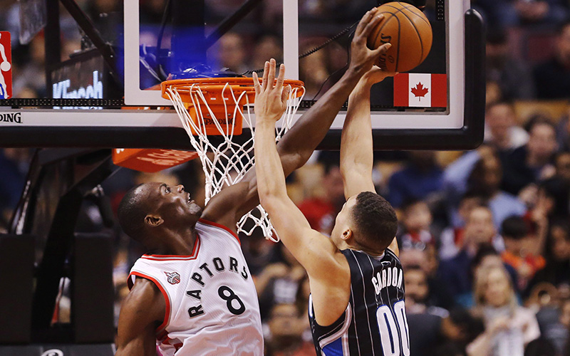Toronto Raptors Bismack Biyombo blocks Orlando Magic Aaron Gordon, right, during the first half of NBA basketball action in Toronto, Sunday March 20, 2016. 