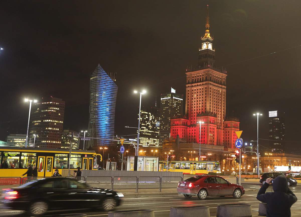 The Palace of Culture, right, the tallest building in the Polish capital, is lit in the colors of the Belgian flag in solidarity with the victims of the attacks in Brussels, in Warsaw, Poland, on Tuesday March 22, 2016.