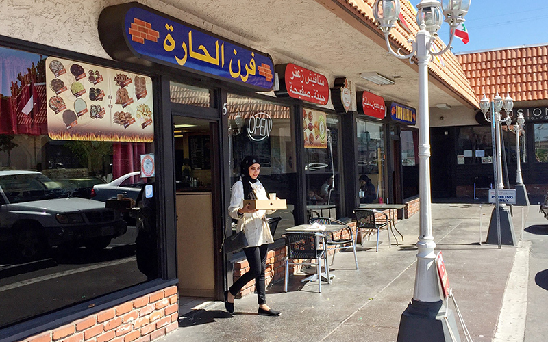 A woman wearing a traditional Muslim head covering exits a Lebanese eatery in Orange County's "Little Arabia" neighborhood just miles from Disneyland.