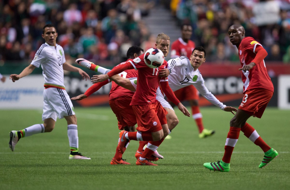 Canada's Marcel De Jong, centre, and Mexico's Hirving Lozano, centre right, vie for the ball during first half FIFA World Cup qualifying soccer action in Vancouver, B.C., on Friday March 25, 2016. 