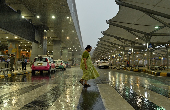 A woman walks through heavy monsoon rainstorm at Indira Gandhi International Airport in New Delhi on July 7, 2015.