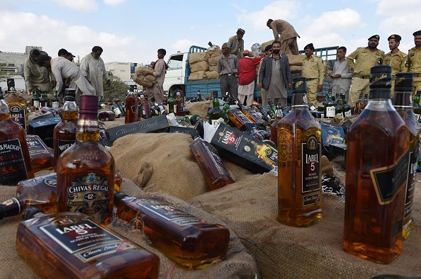 Pakistani customs officials prepare to crush bottles of liquor during a ceremony on the occasion of International Customs Day in Lahore on January 26, 2016. 