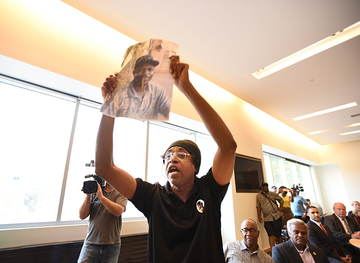 Holding a photo of Andrew Loku, Cecil Peter speaks out against carding during a public consultation on street checks hosted by Yasir Naqvi, the provincial Minister of Community Safety and Correctional Services. Loku was shot by Toronto police and died from his injuries.