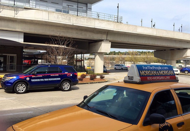 In this March 25, 2016 photo, an Atlanta Police Rides-For-Hire Enforcement vehicle sits amid taxi cabs outside the departures area of the domestic terminal at Hartsfield-Jackson Atlanta International Airport. 