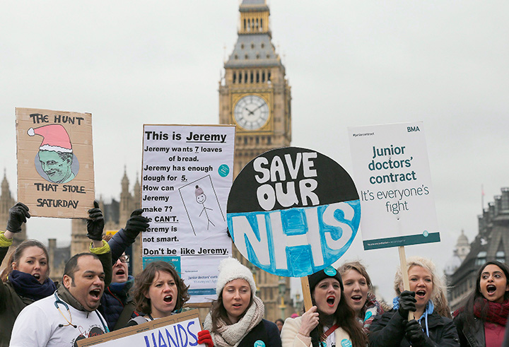 Junior National Health Service doctors wave placards during a protest outside St Thomas Hospital in London, Wednesday, Feb. 10, 2016.  