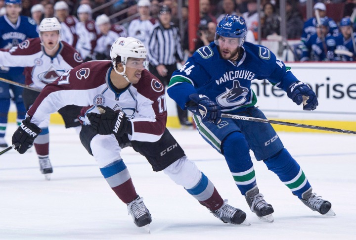 Colorado Avalanche center Andreas Martinsen (27) fights for control of the puck with Vancouver Canucks defenseman Matt Bartkowski (44) during first period NHL action in Vancouver, B.C. Wednesday, March 16, 2016. 