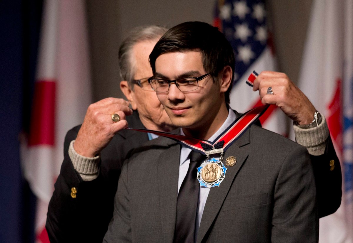 FILE - In this March 25, 2015, file photo, Jon Meis of Renton, Wash., right, is presented by Medal of Honor recipient Medal of Honor recipient Patrick Brady, with a Citizen Service Before Self Honors during a ceremony at Arlington National Cemetery in Arlington, Va. On June 5, 2014, Meis disarmed and subdued a shooter on the campus of Seattle Pacific University. He is one of 24 people being honored with medals and cash from the Pittsburgh-based Carnegie Heroes Fund Commission. The commission's new honorees, will be formally announced Thursday, Dec. 17, 2015.