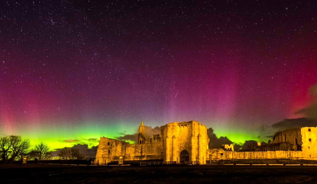 The northern lights over Warkworth Castle in Northumberland, Scotland.