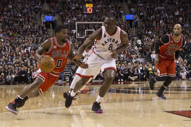 Chicago Bulls' Aaron Brooks, left, drives at Toronto Raptors' Bismack Biyombo, centre, as Bulls' Taj Gibson looks on during second half NBA basketball action in Toronto on Monday, March 14, 2016. THE CANADIAN PRESS/Chris Young.
