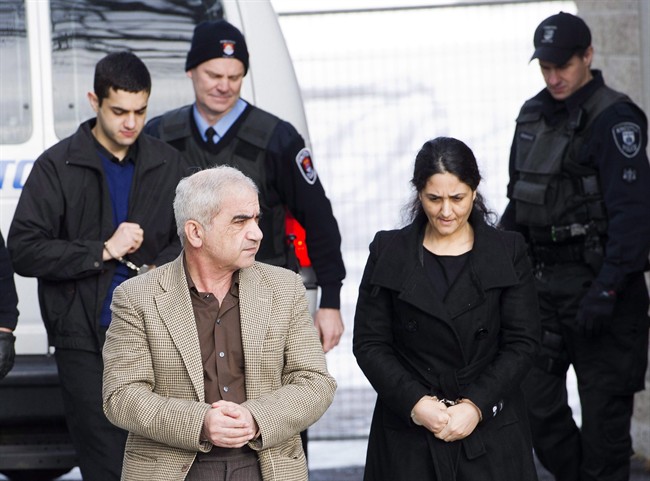 Mohammad Shafia, front left, Tooba Yahya, front right, and their son Hamed Shafia, back left, are escorted at the Frontenac County courthouse in Kingston, Ont., on January 28, 2012. 