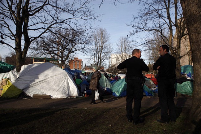 Victoria Police watch over residents at the homeless camp, also known as InTent City, during a block party at the camp in Victoria, B.C., Thursday, February 25, 2016. 