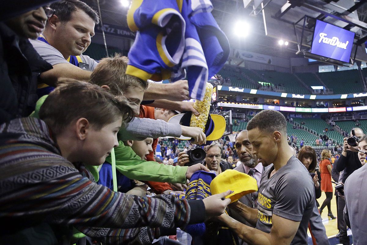 THE BEFORE PHOTO: Golden State Warriors guard Stephen Curry, right, signs autographs before the start of their game with the Utah Jazz .